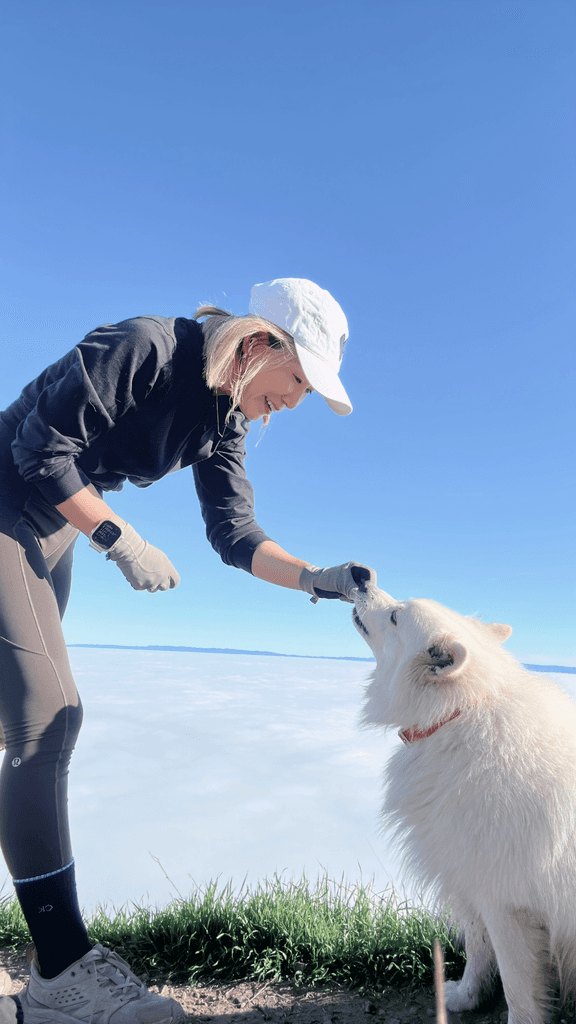 June on a hilltop with her white dog